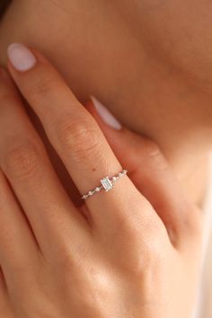 a woman's hand with a diamond ring on it