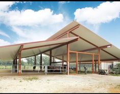 a large metal building sitting on top of a dirt field