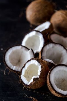 some coconuts are sitting on a table with one cut in half and the other whole