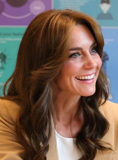 a woman with long brown hair smiles at the camera