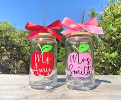 two mason jars decorated with apple and mr and mrs smith on the lids, tied with red ribbon