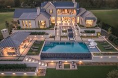 an aerial view of a large house with a pool in the middle and lots of lights around it