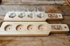 four shot glasses sitting on top of a wooden holder with holes in the middle that says never trust a beer don't lie