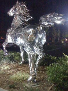 a statue of a horse that is standing in the grass