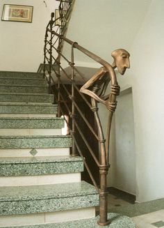 a stair case with a statue on top of it next to some stairs in a house