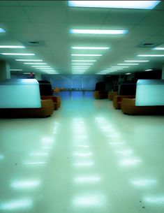 an empty room with couches and lights on the ceiling is shown in this image