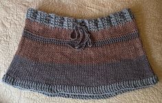 a close up of a knitted skirt on a bed