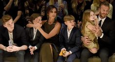 a group of people sitting next to each other in front of a crowd at a fashion show