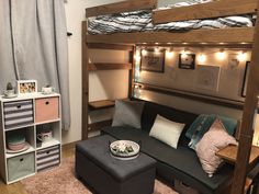 a loft bed with a couch underneath it and lights on the wall behind it in a bedroom