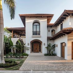 a large white house with palm trees in the front yard and walkway leading up to it