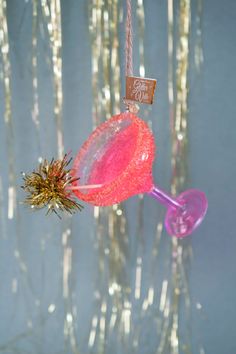 a pink glass ornament hanging from a string