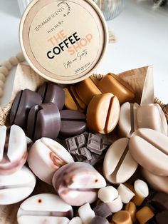 a basket filled with lots of different types of candies next to a bottle of coffee