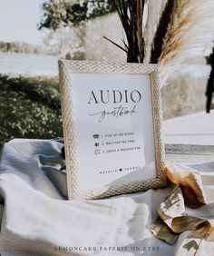 a sign sitting on top of a table next to dry grass and dried plants in front of it