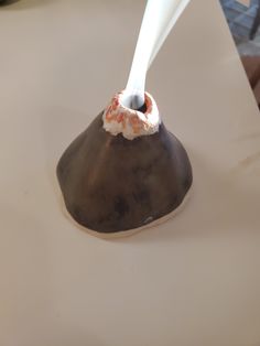 a white toothbrush is sticking out of a chocolate covered object on a counter top