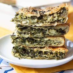 three pieces of spinach pie stacked on top of each other in a white plate