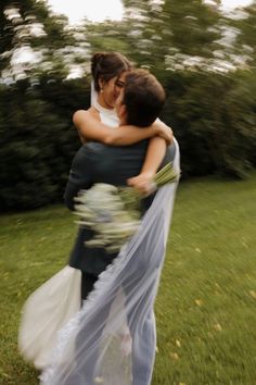 two people hugging each other in the grass