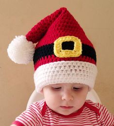 a small child wearing a santa hat while sitting at a table