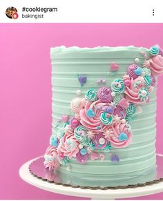 there is a blue cake with pink and blue frosting on the top that has hearts in it