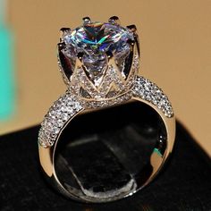 a diamond ring is displayed on a black surface