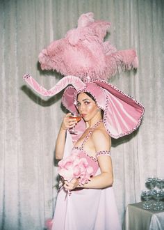 a woman in a pink hat and dress