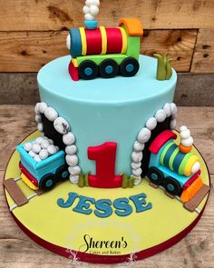 a birthday cake for a one year old boy with a train on the front and number 1 on the back