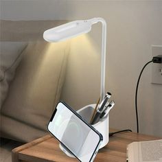 a lamp that is sitting on top of a table next to a book and pen holder