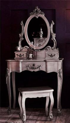 an antique dressing table with mirror and stool