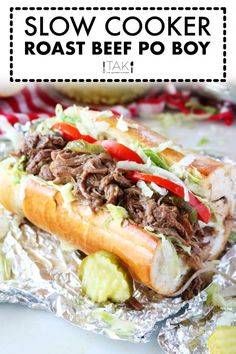 a close up of a sandwich on tin foil with the words slow cooker roast beef po boys