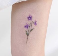 a small purple flower tattoo on the leg