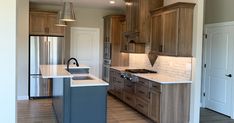 an empty kitchen with wooden cabinets and white counter tops, along with stainless steel appliances