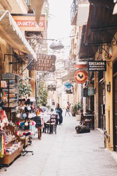 an alley way with shops and people walking down it