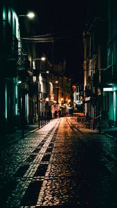 an empty city street at night with no one on the sidewalks or people walking down it