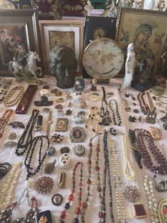 a table topped with lots of different types of necklaces and other items on display