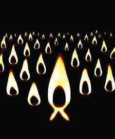 many lit candles are arranged in the shape of tears