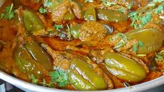 a pot filled with meat and vegetables covered in gravy, garnished with parsley