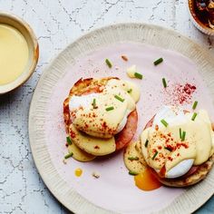 two eggs benedicts on toasted english muffins with butter and chives