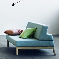 a blue chair with two pillows on it