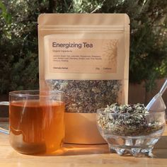 a glass bowl filled with tea next to a bag of tea