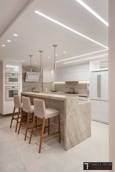 a kitchen with marble counter tops and bar stools