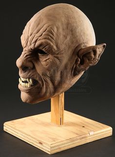 an old man's head on a wooden stand