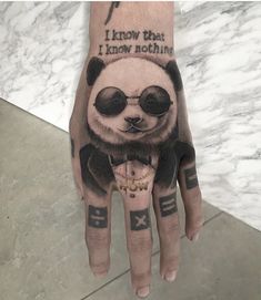 a person's hand with a panda bear tattoo on it and the words i know that i know nothing