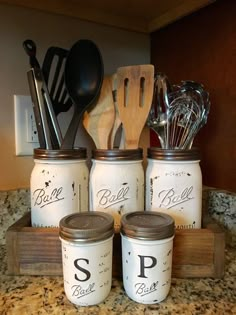 four mason jars with spoons and spatulas in them