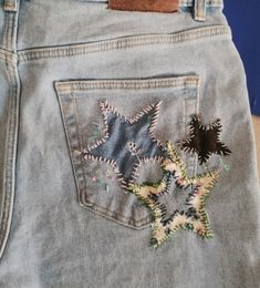 a pair of jeans with embroidered stars on them