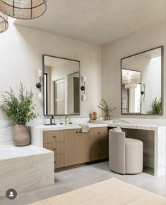 a bathroom with two sinks, mirrors and stools in the middle of the room