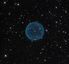 an image of a blue object in the middle of some dark space with stars around it