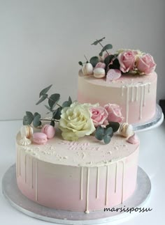 two cakes decorated with flowers on top of each other