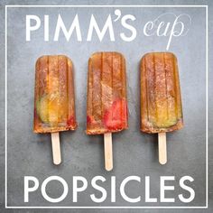 three popsicles with fruit on them sitting next to the words pimm's cup