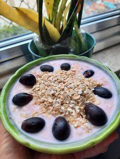 a bowl of oatmeal with black olives and granola in it