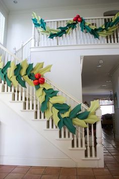 a decorated christmas garland on the bannister of a house in front of stairs