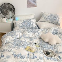 a bed with blue and white comforters in a bedroom next to a night stand